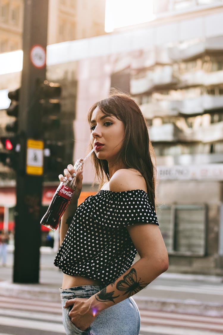 Woman Drinking Soft Drink On The Street