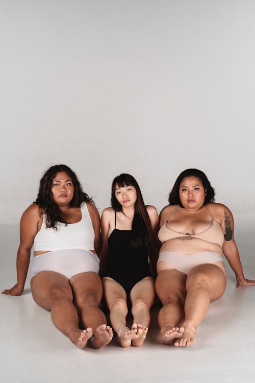 Calm Asian women in underwear sitting on floor in studio