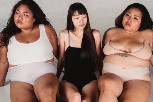 Serene Asian women in underwear sitting on floor