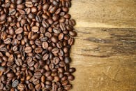 乡村木桌上散落的闪亮芳香烘焙咖啡豆的顶视图