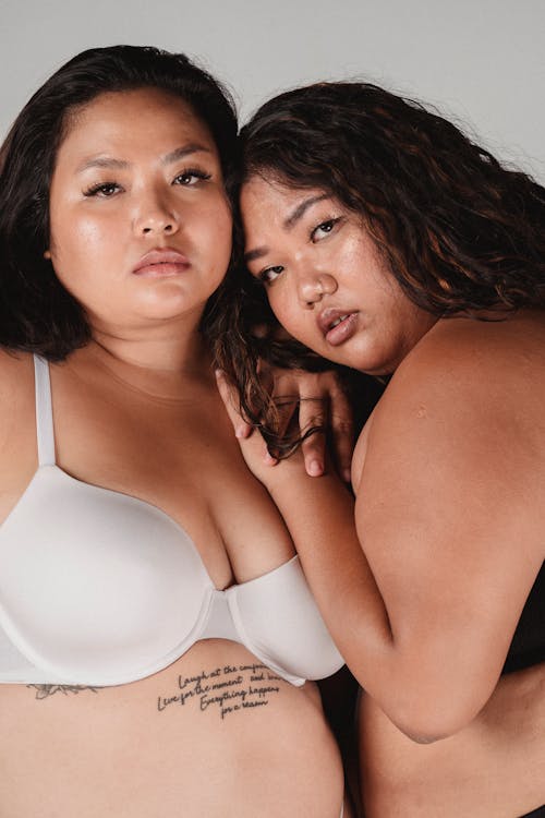 Free Serious plump Asian women cuddling in studio Stock Photo