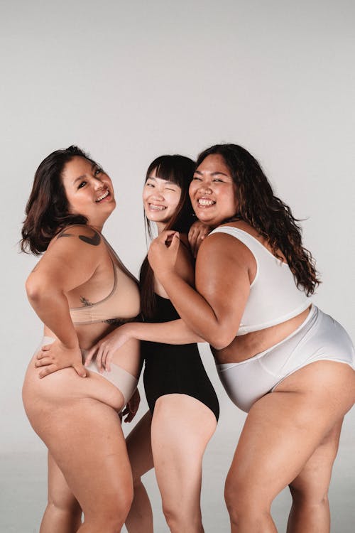 Happy Asian models embracing in studio