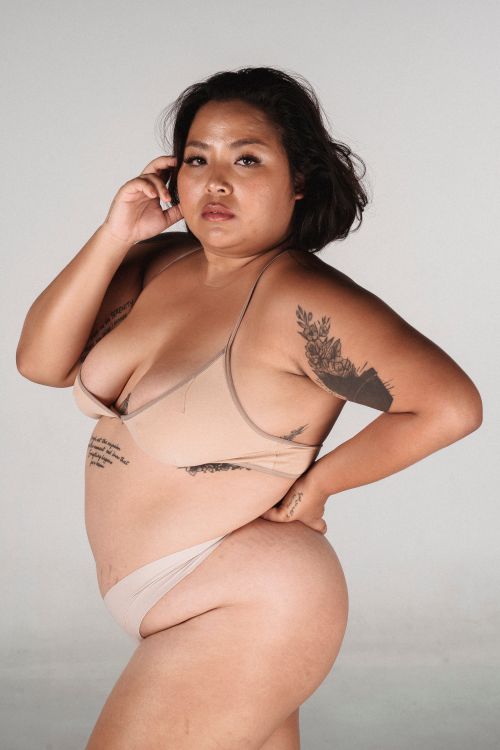 Free Plus size ethnic female with hand on waist looking at camera on white background Stock Photo