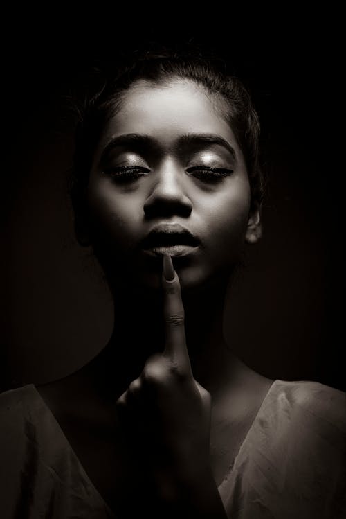 Grayscale Photo of Woman Pointing Her Finger on Lips 