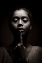 Grayscale Photo of Woman Pointing Her Finger on Lips