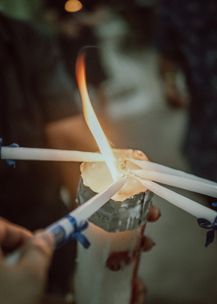 People Lighting Candles From Flame Of Big Candle