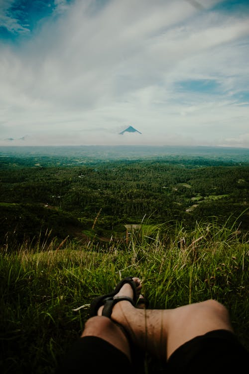 Person Sitting on Green Grass Field 