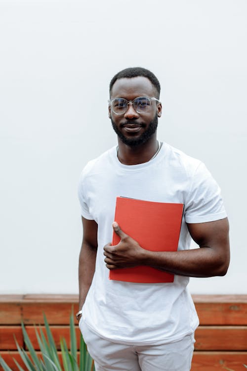 Free Man in White Crew Neck T-shirt Holding Red Paper Stock Photo