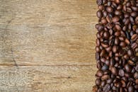 质朴的木桌上散落着新鲜的咖啡豆，非常适合温暖自然的主题