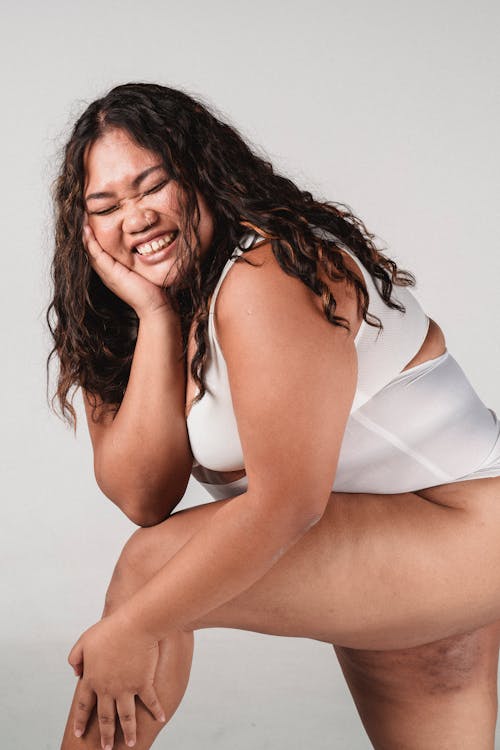 Cheerful overweight woman in underwear smiling