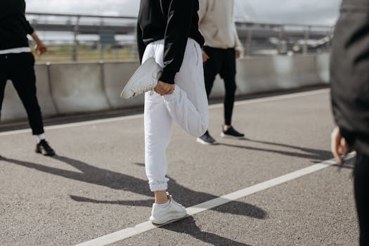 A diverse group of adults stretching and warming up on an urban road outdoors.