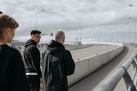 一群年轻朋友白天一起在现代化的城市桥梁上散步