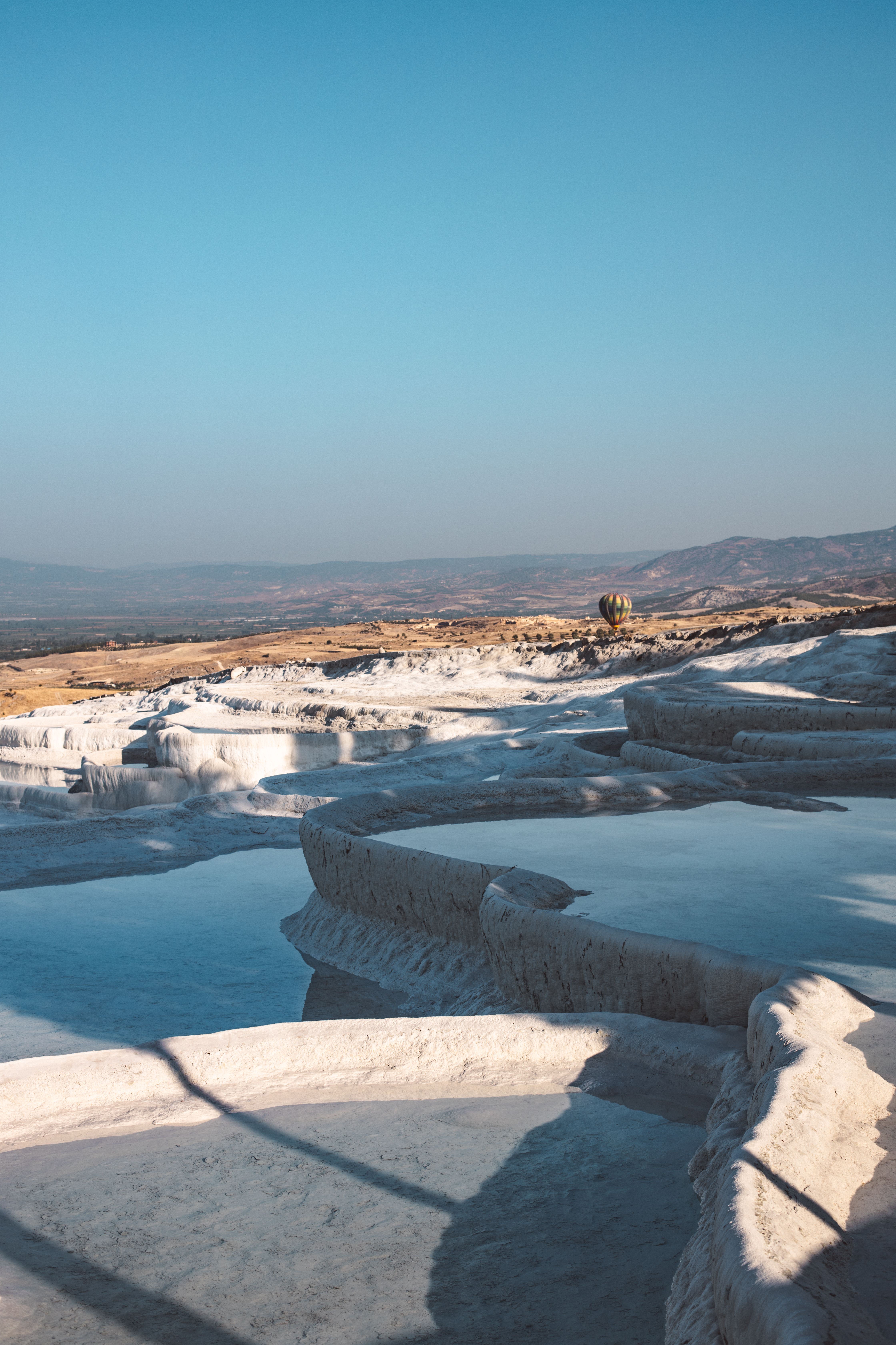 Breathtaking view of Pamukkale's thermal salt terraces under a clear sky.