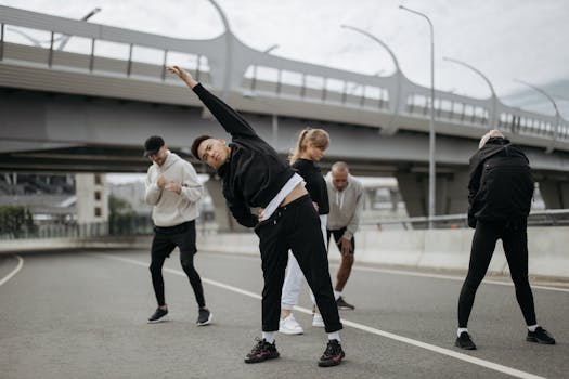 A diverse group of adults stretching during an outdoor fitness session under a city bridge.