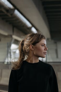 城市环境中，一名女性侧过脸，表情平静地移开目光