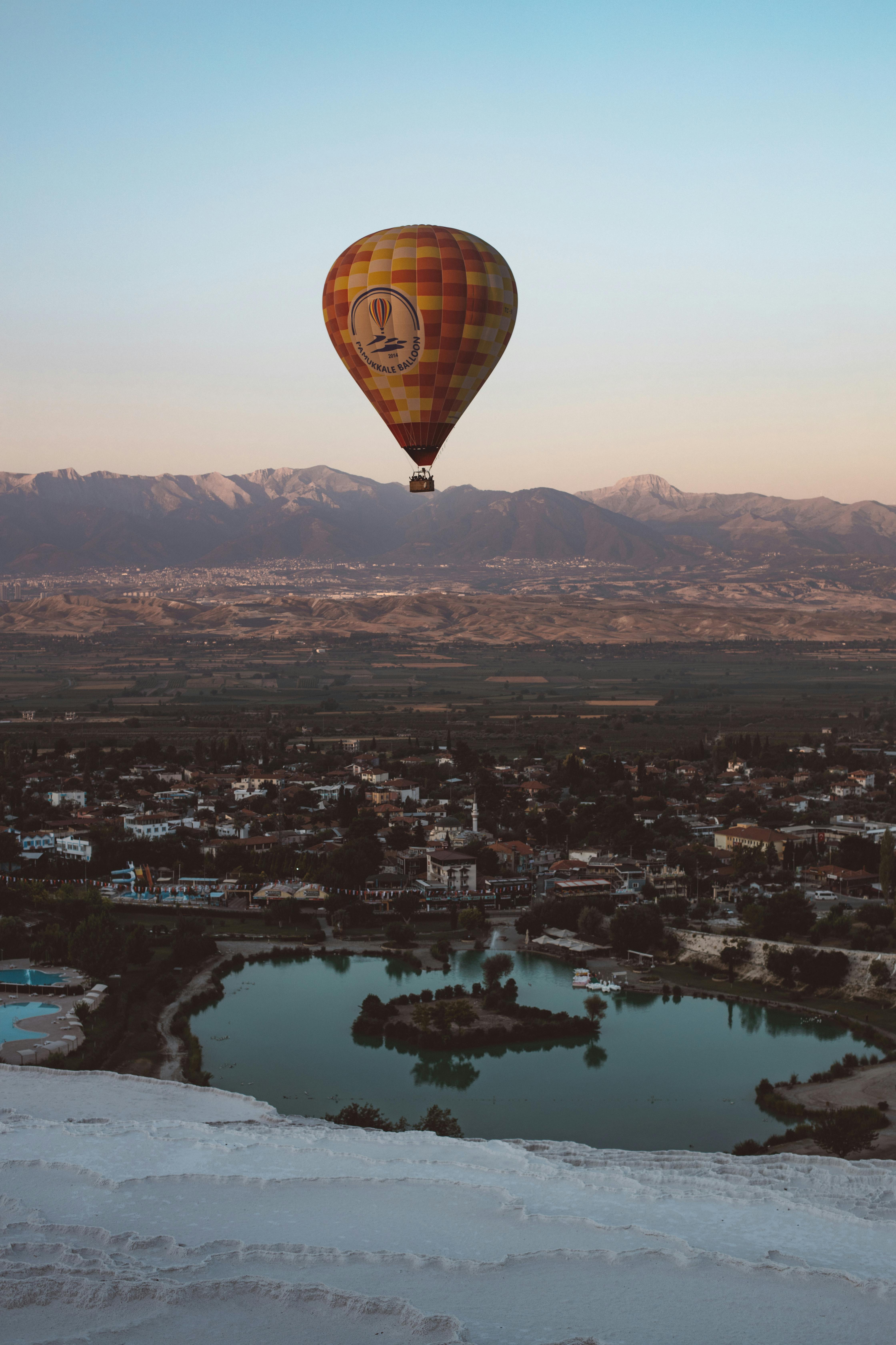 hot air balloon flying over the city during sunset