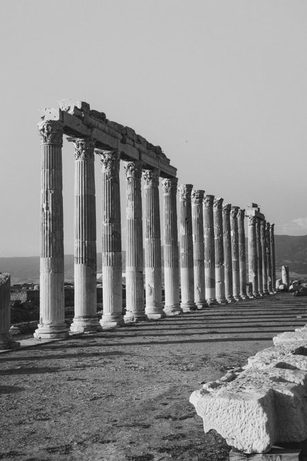 Black and white photo of ancient stone columns in Türkiye, depicting historical ruins.