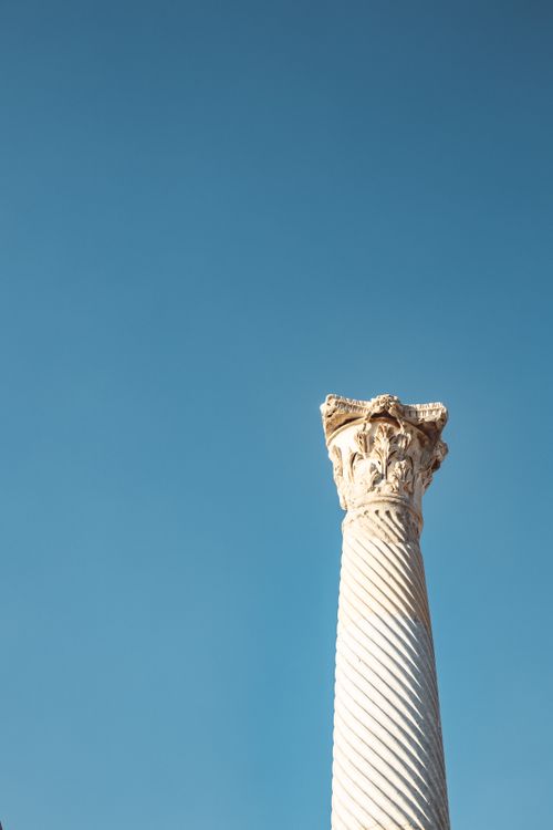 Free Spiral ancient column under a clear blue sky, representing historical architecture. Stock Photo
