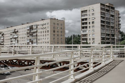 Free View of a modern urban bridge with towering city buildings under a cloudy sky. Stock Photo