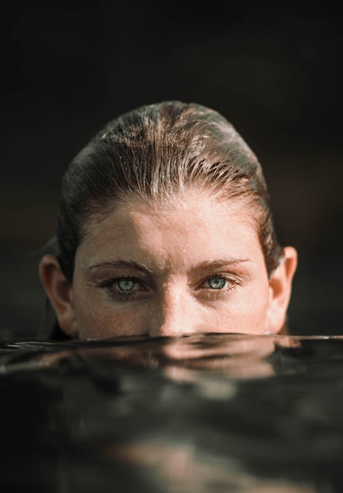бесплатная Мирная молодая женщина, погруженная в морскую воду в солнечный день Стоковое фото