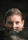 Peaceful young woman submerged in sea water on sunny day