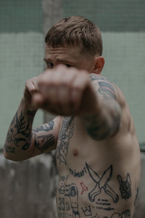 Man With Tattoo Throwing a Punch