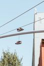 Sneakers hanging on metal chimney near wires