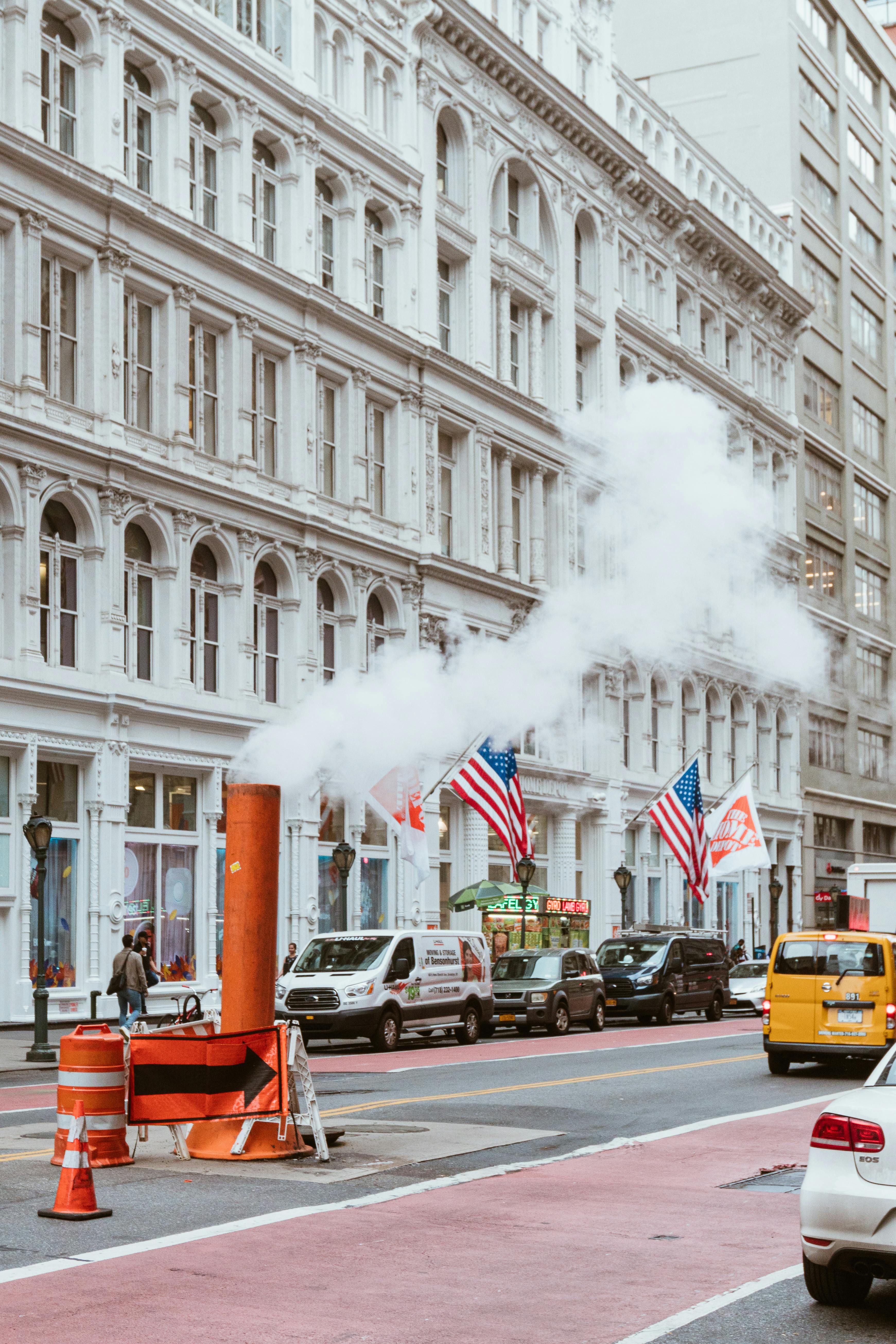 busy repairing street with cars and steam from pipe