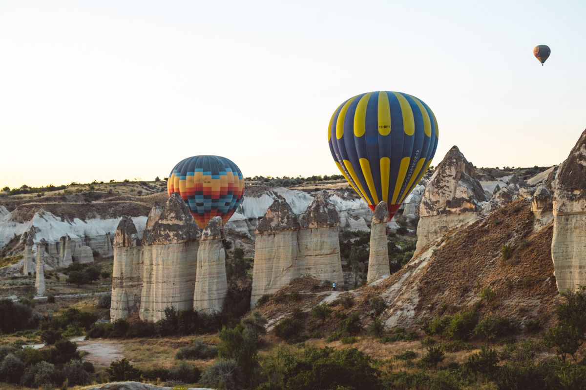 Hot-air balloons drifting over the fairy chimneys of Cappadocia at dawn