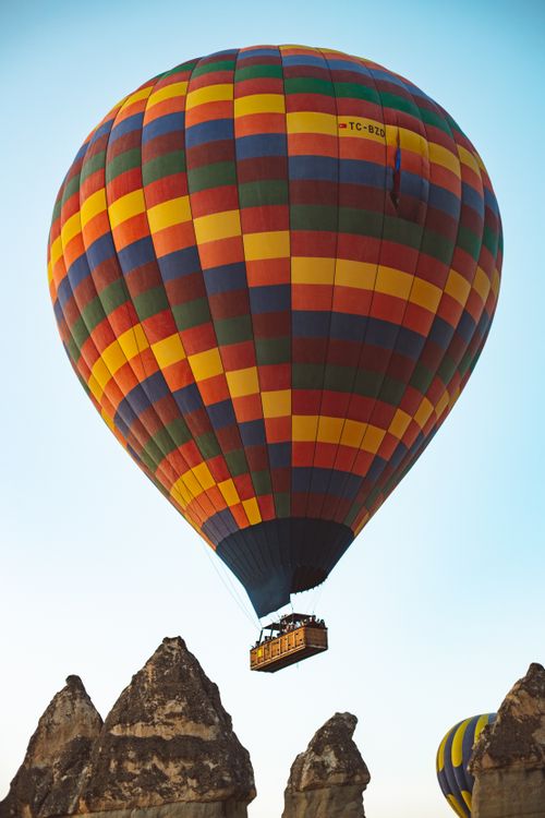 Free Vibrant hot air balloon soaring over Cappadocia's unique rock formations during the day. Stock Photo