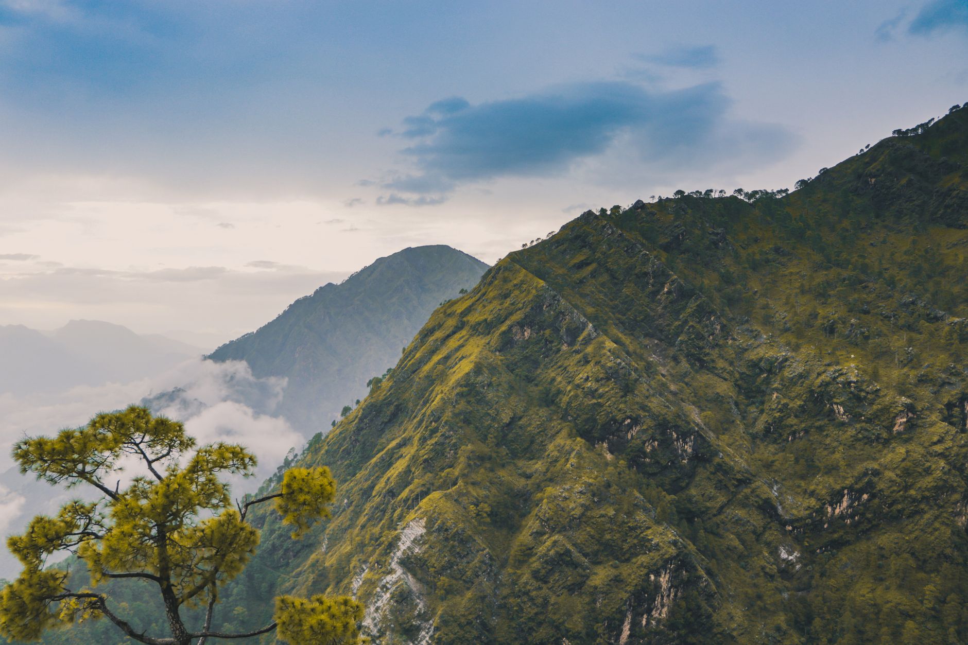 A breathtaking view of lush green mountain hills under a blue sky, perfect for nature lovers.