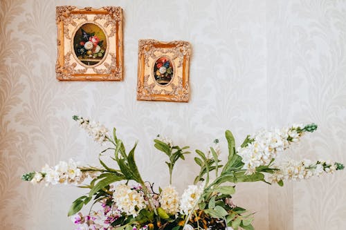 Free Blossoming flower bouquet with gentle petals near ornamental wall with paintings in house Stock Photo