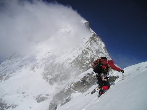 Person Climbing Glacier Mountain during Day