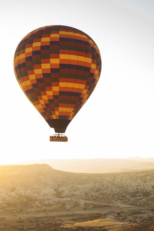 Free Colorful hot air balloon floats over Cappadocia's captivating landscape during sunrise. Stock Photo