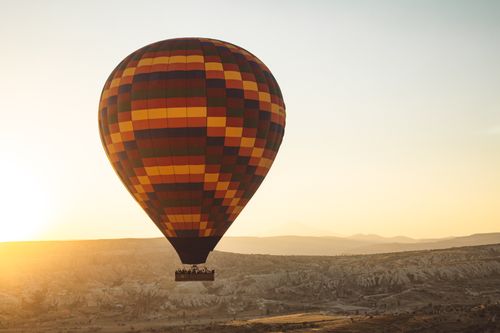 Free A colorful hot air balloon soars over Cappadocia's unique landscape at sunrise, Turkey. Stock Photo