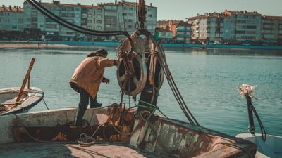 Fisherman working a winch on a boat deck, photo by seyfi durmaz on Pexels