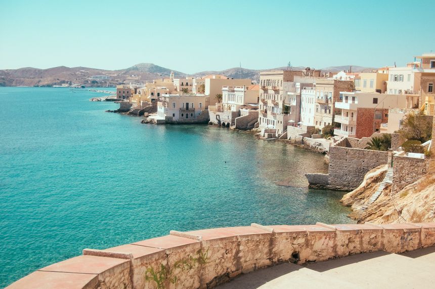 A turquoise bay below the ochre houses of a hillside island town