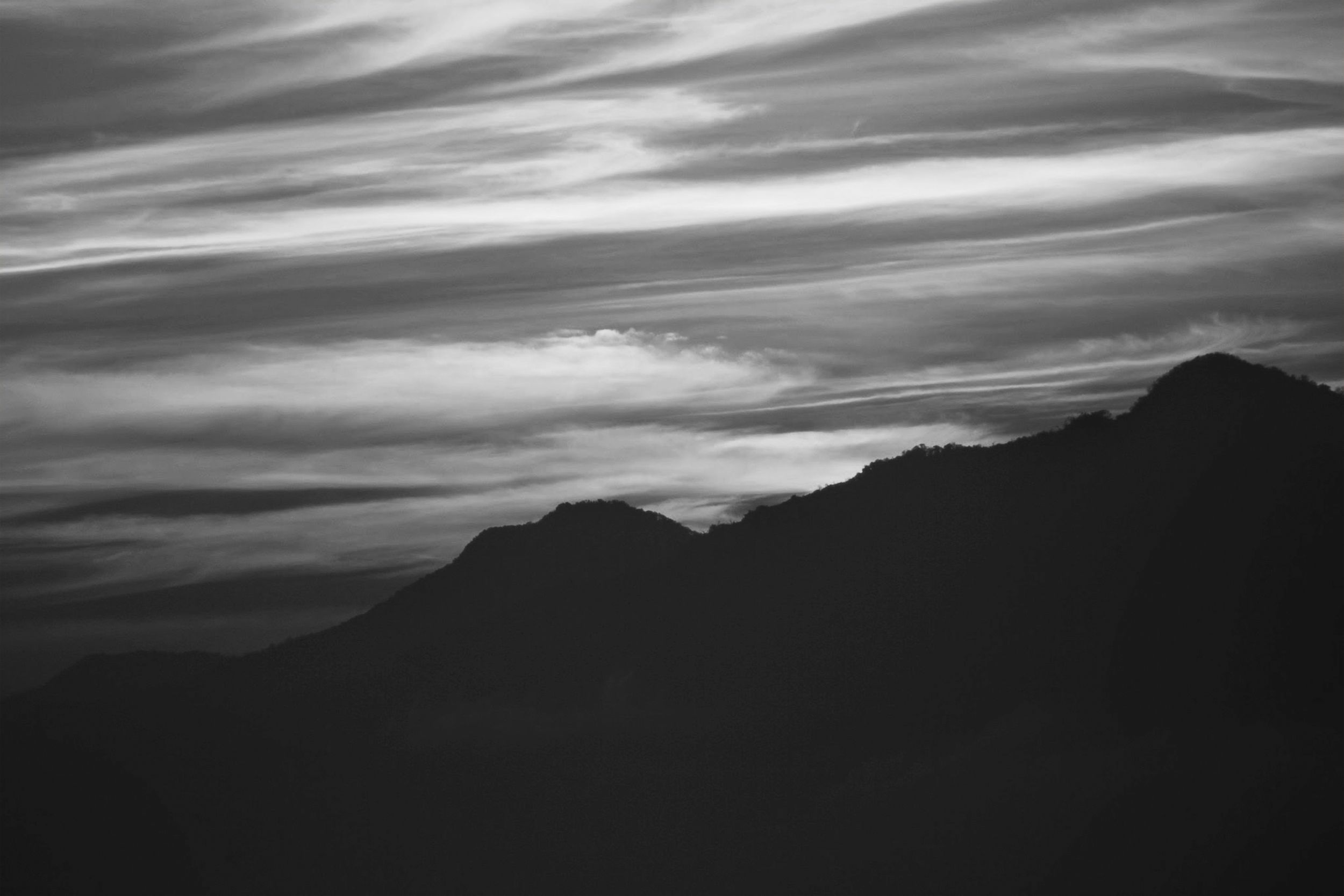 Monochrome landscape of mountains in India with dramatic cloudy sky.