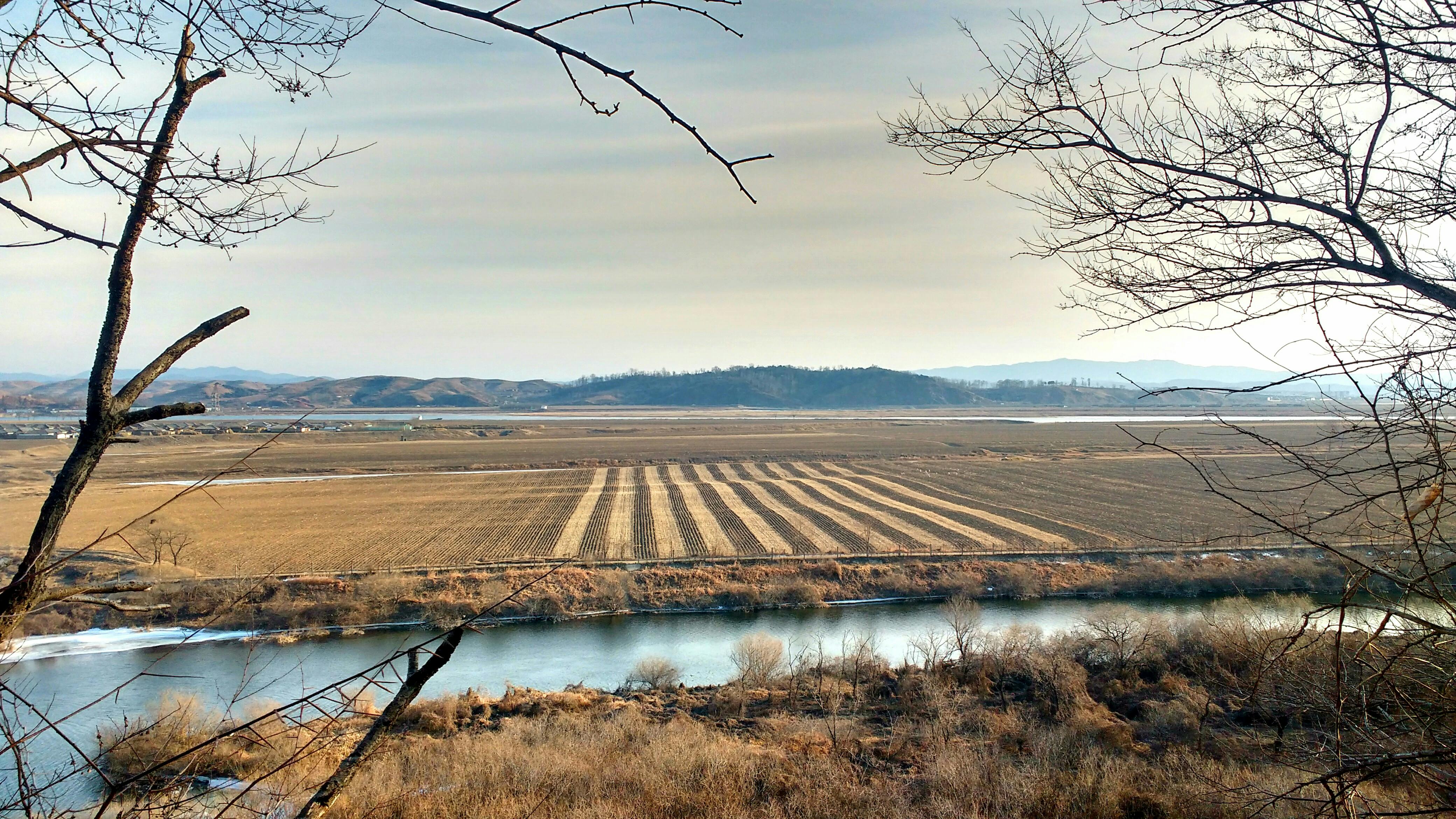 Peaceful landscape of a river and cultivated fields in China's countryside.
