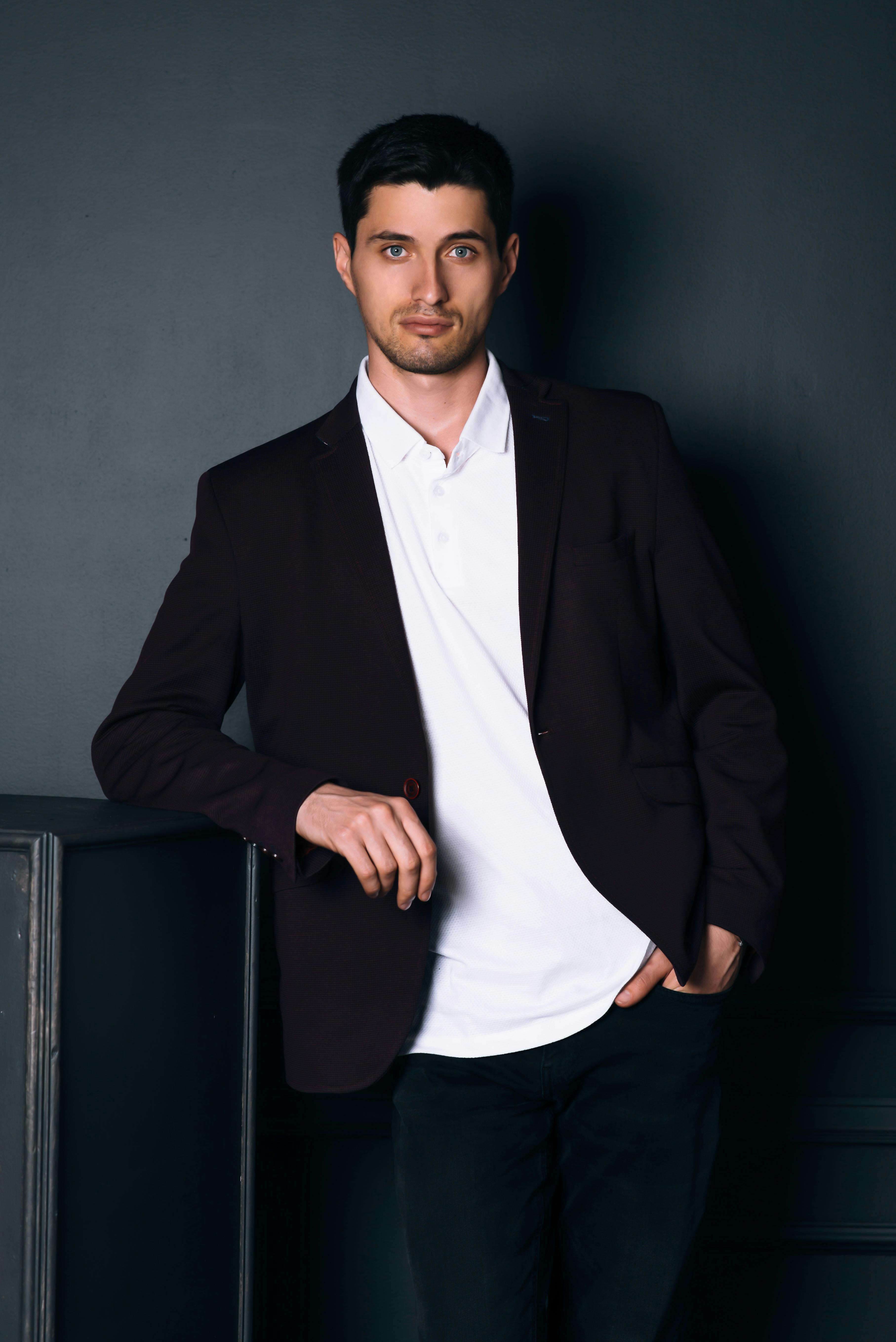 Man standing near the table while his hands in his pocket. | Photo: Pexels