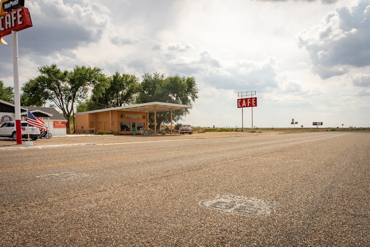 Cafe Signage And Building Along A Road Under A Cloudy Sky