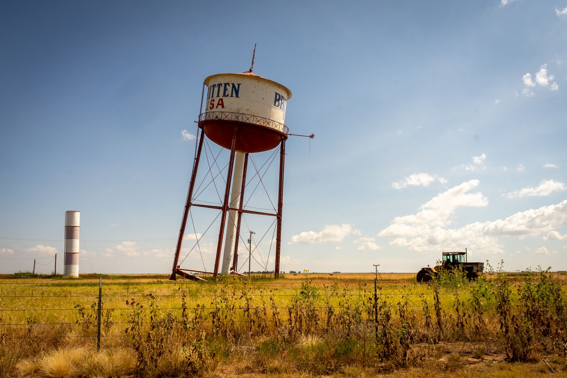 The famous leaning water tower of Britten, Texas in a vast countryside landscape.