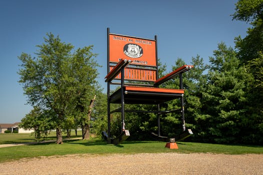 World's largest rocking chair on Route 66 among green trees under clear skies.