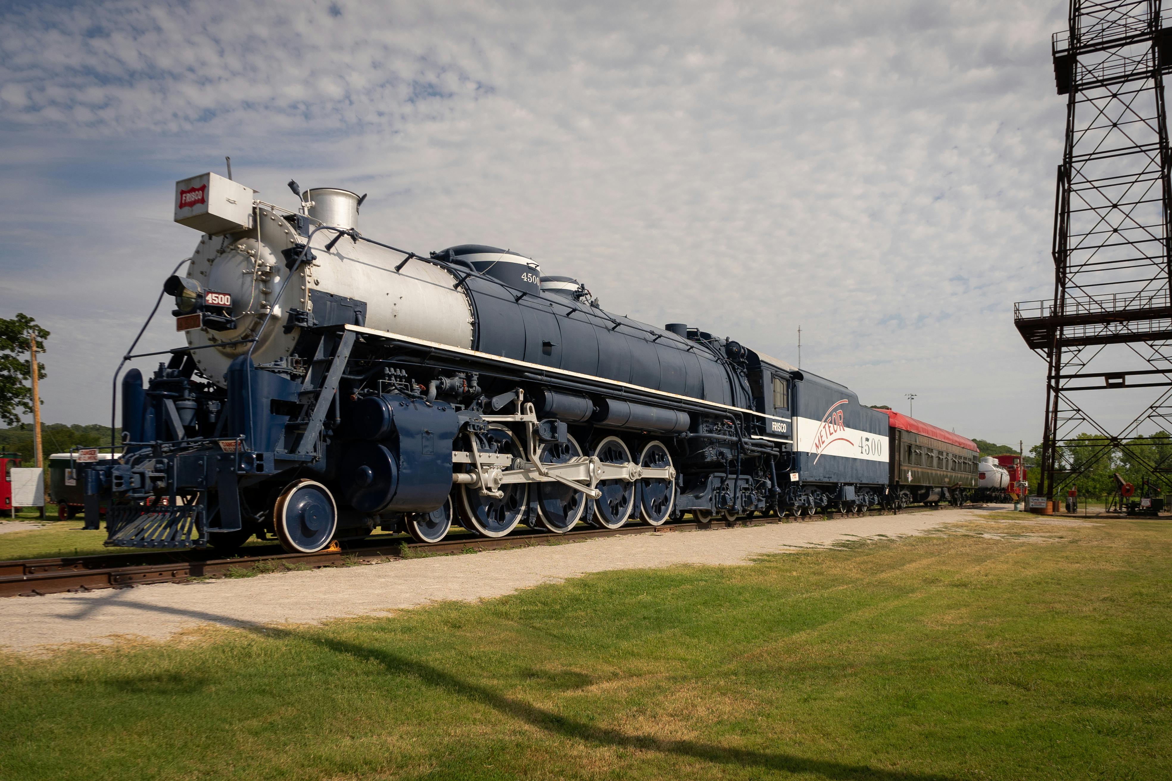 A classic steam locomotive captured on a sunny day, showcasing its historic charm.