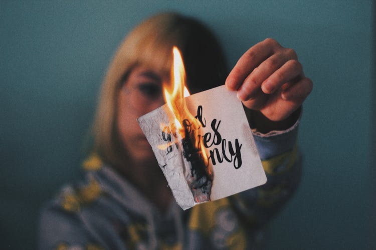 Anonymous Woman Burning Paper With Inscription