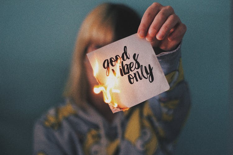 Anonymous Woman Demonstrating Burning Paper Sheet With Title