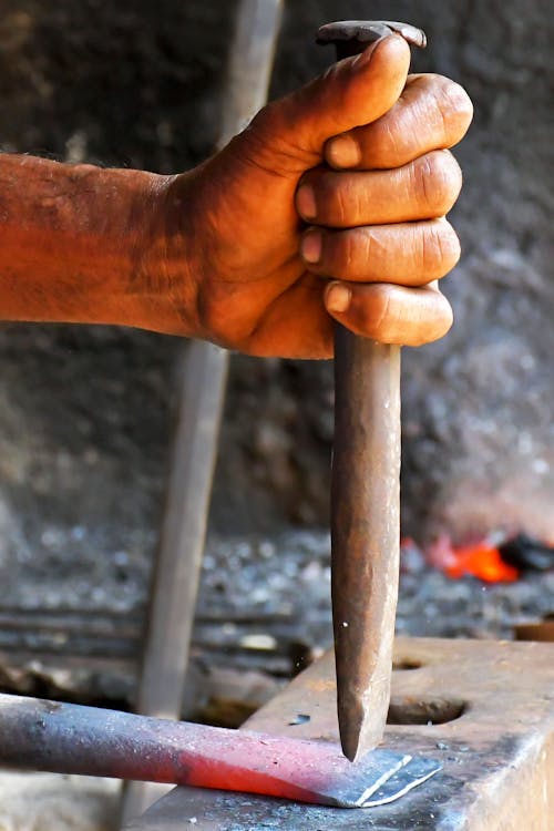 Close up on Blacksmiths Hand and Hot Metal