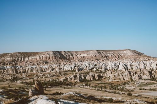 Free A stunning view of Cappadocia's unique rock formations with a clear blue sky backdrop. Stock Photo