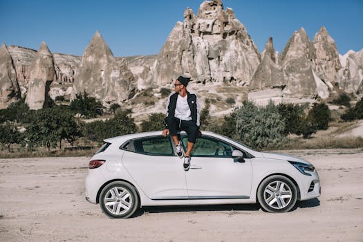 在卡帕多西亚，一名男子坐在一辆白色岩石结构的汽车上，探索大自然的美丽