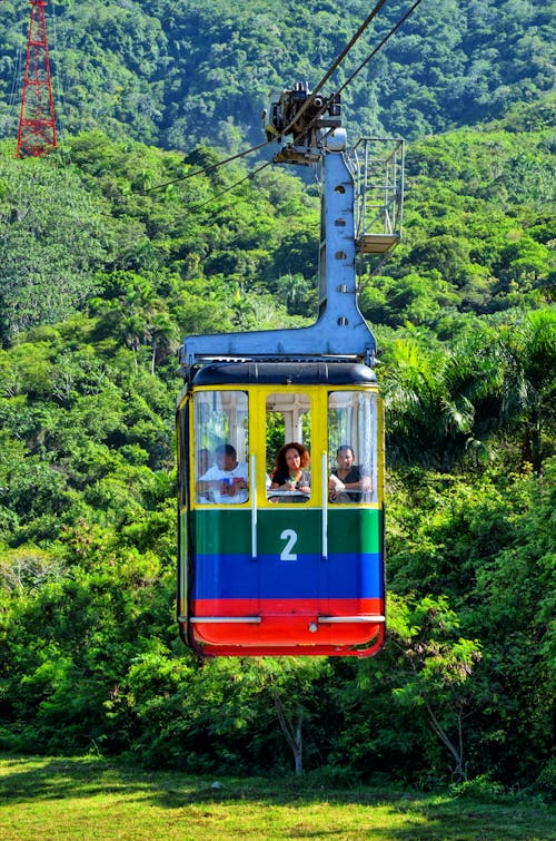 Free People Riding a Cable Car Near Trees Stock Photo